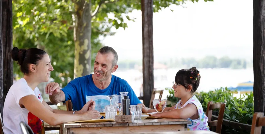 Andrea è seduto al tavolo di un ristorante insieme alla sua famiglia. Per domande o dubbi sulla vescica e sull'intestino quando si convive con la SM, contatta Coloplast Care per ricevere assistenza.  