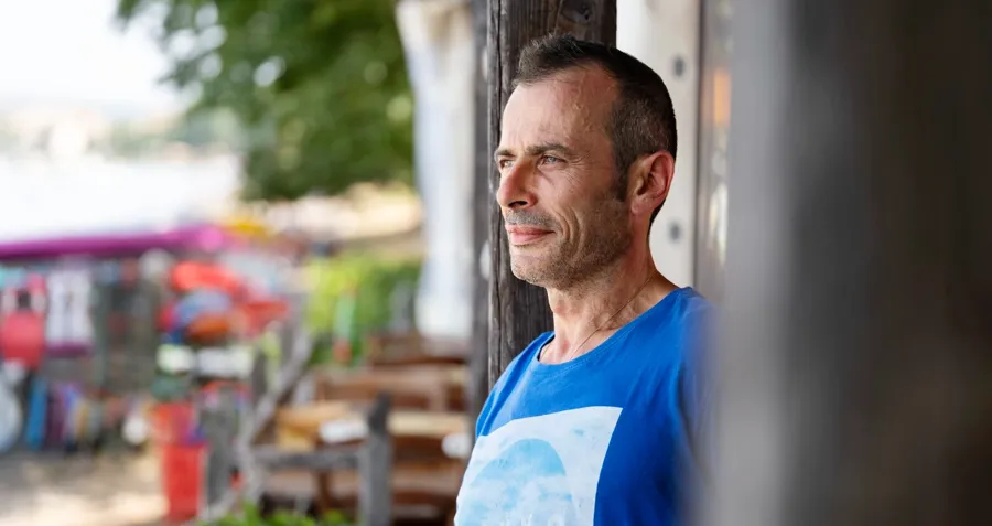 Foto ritratto di Andrea all'aperto. Il cateterismo intermittente richiede un processo di apprendimento e, col tempo, Andrea ha imparato a praticarlo fuori casa e ha sviluppato una routine adatta alle sue esigenze. 