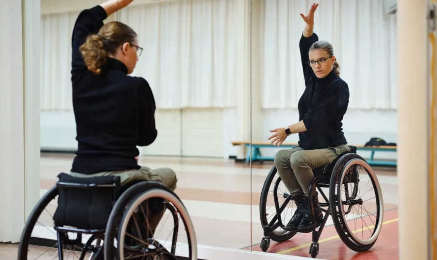 Foto di Marianne nella sua sala da ballo. Marianne ha scoperto il ballo in sedia a rotelle e insieme al suo partner esegue balli come la rumba, il paso doble e il cha cha cha. 