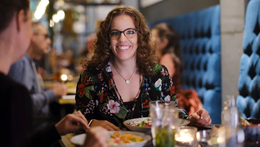Foto di Marianne a cena fuori con gli amici. Marianne ha una buona rete di sostegno, con amici che la aiutano. 