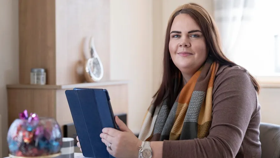 Foto di Sarah seduta a un tavolo. Sono passati quattro anni dalla diagnosi iniziale prima che Sarah collegasse i suoi problemi alla vescica alla sclerosi multipla. 